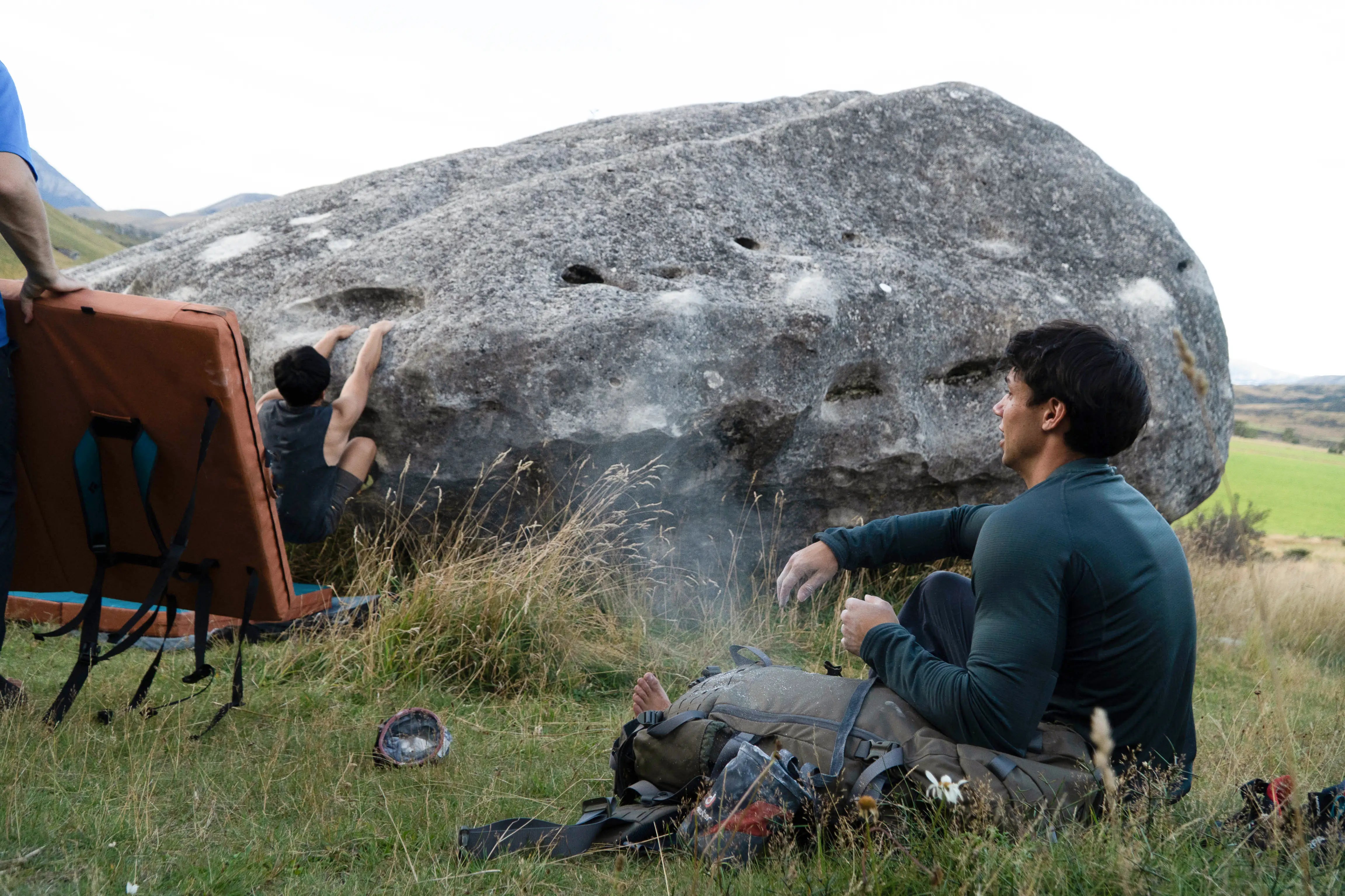 Friends outside having fun bouldering with thermals, hiking gear.
